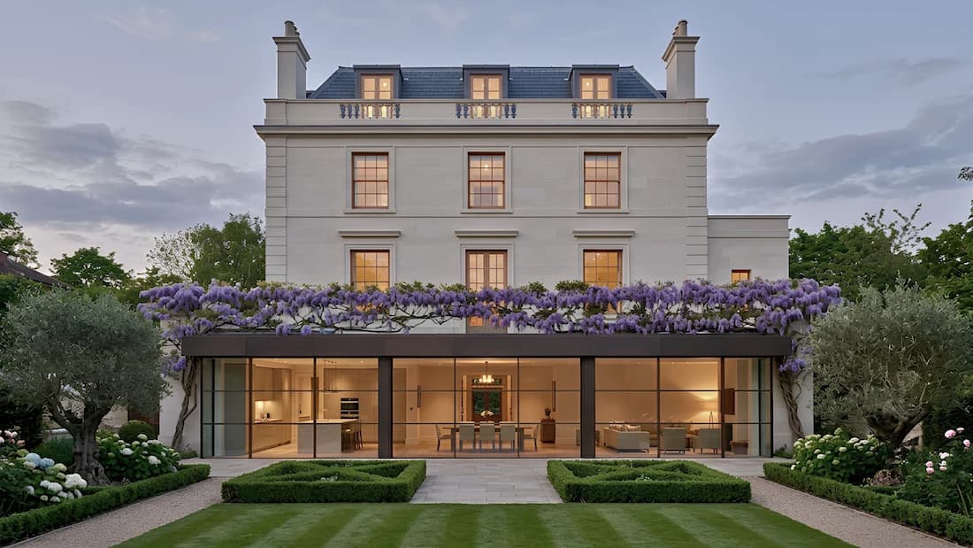 Home extension Holland Park London — evening facade photography | Sovran Group Home extension in Holland Park, London — wisteria-clad stucco facade; glazed rear extension opening onto a landscaped garden, by Sovran Group