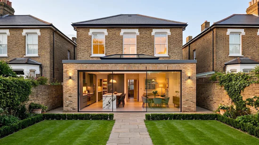 Rear extension Balham London — roof lantern and sliding glass doors | Sovran Rear extension in Balham, London — single-storey brick extension with a roof lantern and full-width sliding glass doors opening onto a lawn, by Sovran